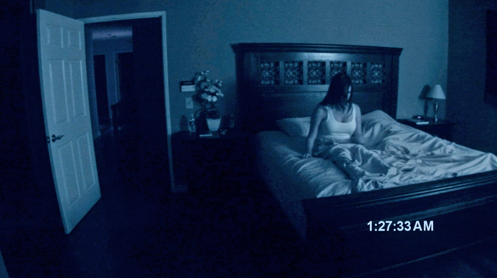 A woman sitting in a bed in "Paranormal Activity"