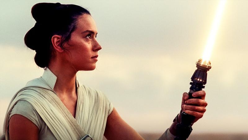 Daisy Ridley as Rey with yellow lightsaber.