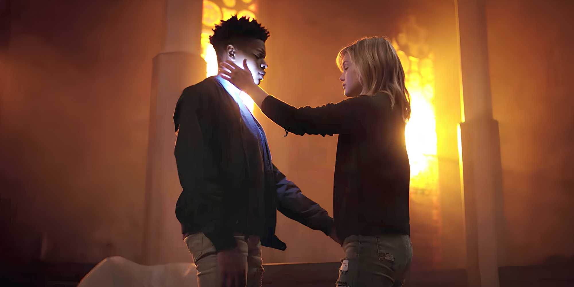 Tandy/Dagger (Olivia Holt) and Tyrone/Cloak (Aubrey Joseph) look at each other intently as a bright light streams through the windows behind in Cloak & Dagger.