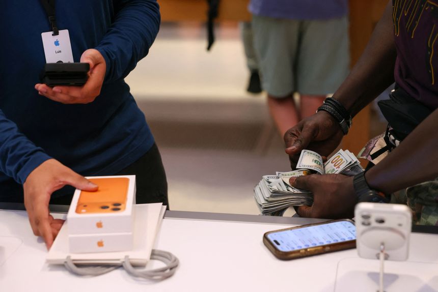 A man purchases an iPhone 17 series with cash at the Apple Store in New York City, on September 19, 2025.