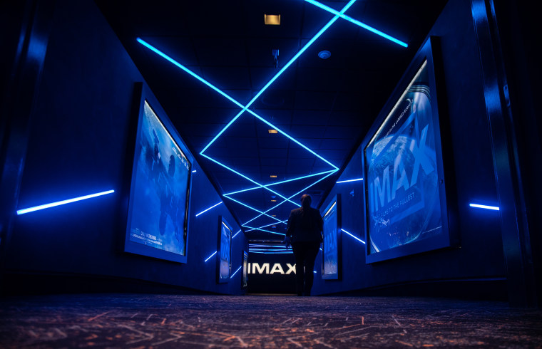 A darkened movie theatre hallway with blue lighting.