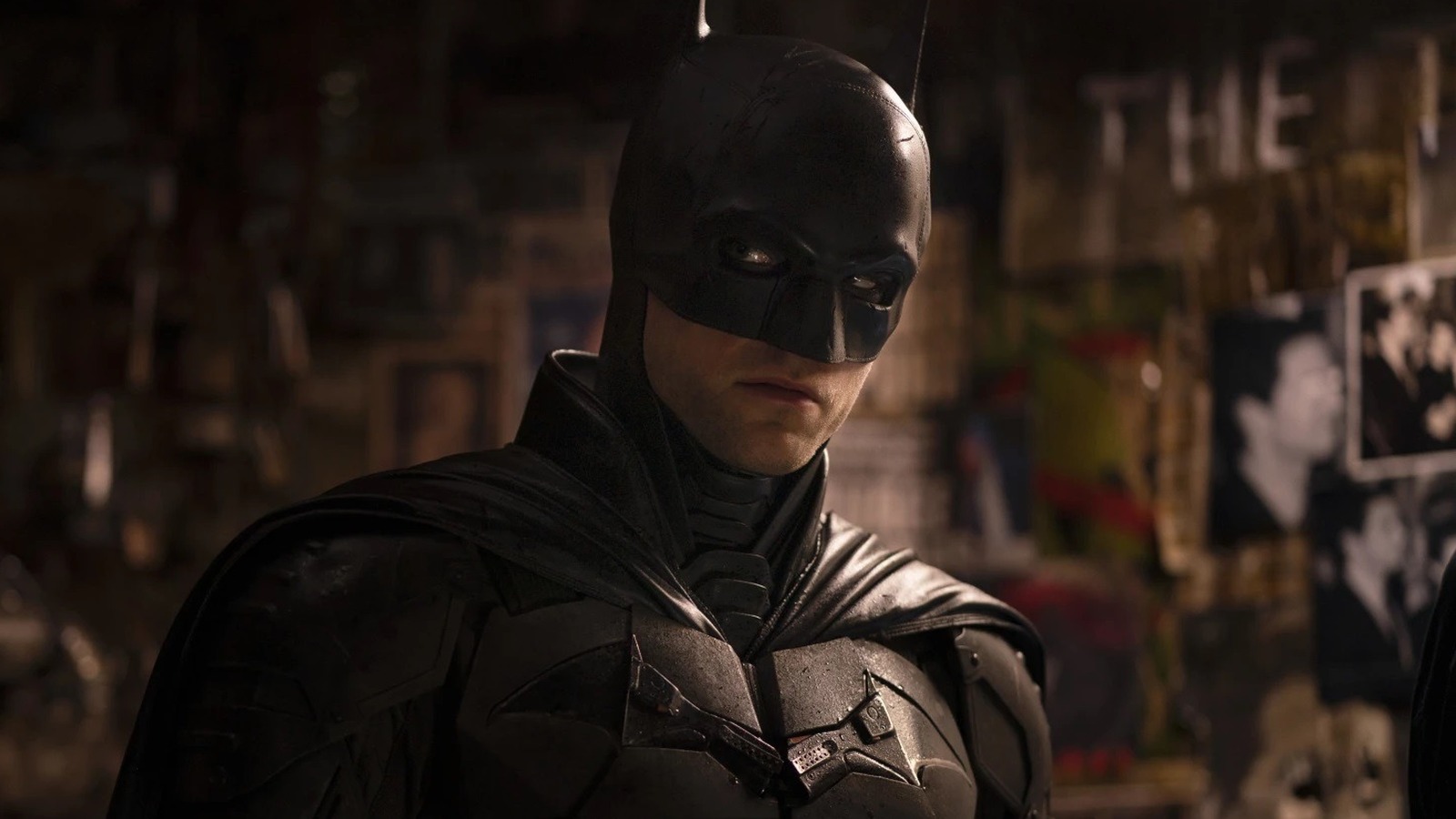 Batman standing next to a wall of pictures in "The Batman"