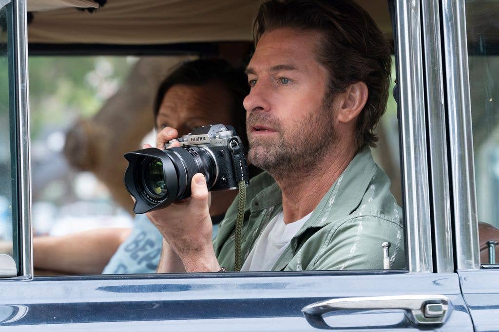 man holding camera in passenger seat of car