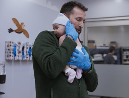Noah Wyle holds a newborn baby
