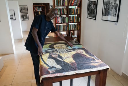 Joseph Oduro-Frimpong displays a hand-painted film poster on a table.