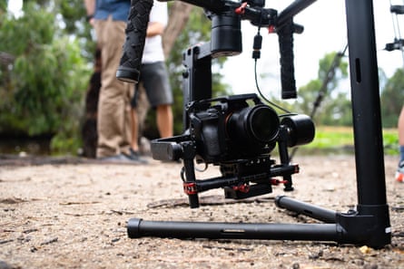 A mirrorless camera on a gimbal with people in the background