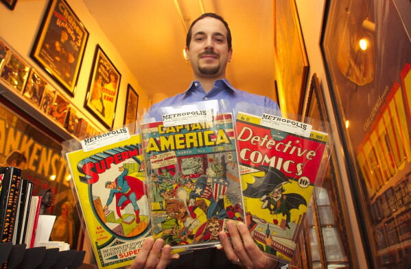 Vincent Zurzolo, co-partner of Metropolis Collectibles, holds three examples of the company's vast collection of comic books in their offices in New York, Thursday, July 10, 2003. (AP Photo/Gregory Bull, File)
