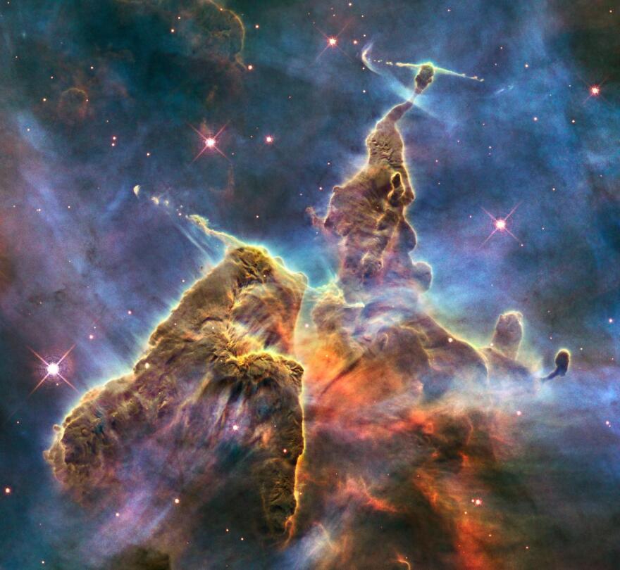 This brand-new Hubble photo is of a small portion of one of the largest seen star-birth regions in the galaxy, the Carina Nebula. Towers of cool hydrogen laced with dust rise from the wall of the nebula. The scene is reminiscent of Hubble's classic "Pillars of Creation" photo from 1995 but is even more striking in appearance. The image captures the top of a three-light-year-tall pillar of gas and dust that is being eaten away by the brilliant light from nearby bright stars. The pillar is also being pushed apart from within, as infant stars buried inside it fire off jets of gas that can be seen streaming from towering peaks like arrows sailing through the air.

The Pillars of Creation can be seen in Smithsonian Starstruck: An Immersive Experience .