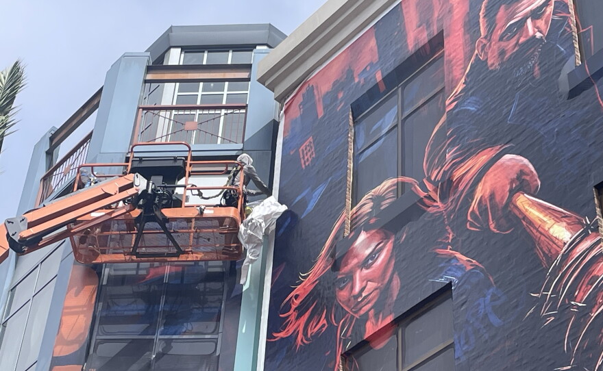 Crews taking down the building wraps in downtown San Diego after Comic-Con ended, July 27, 2026.