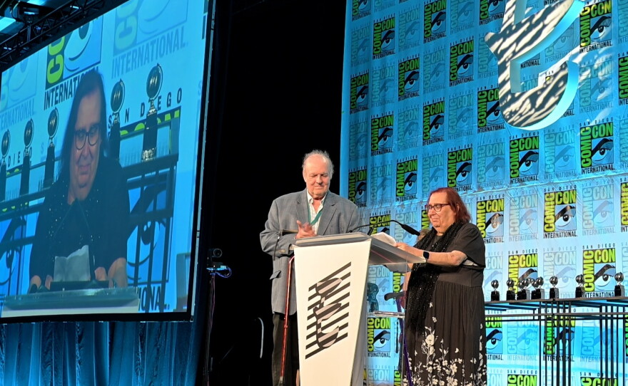 Mark Evanier presenting the Bill FingerExcellence in Comics Writing Award to Jenny Blake Isabella. July 24, 2026