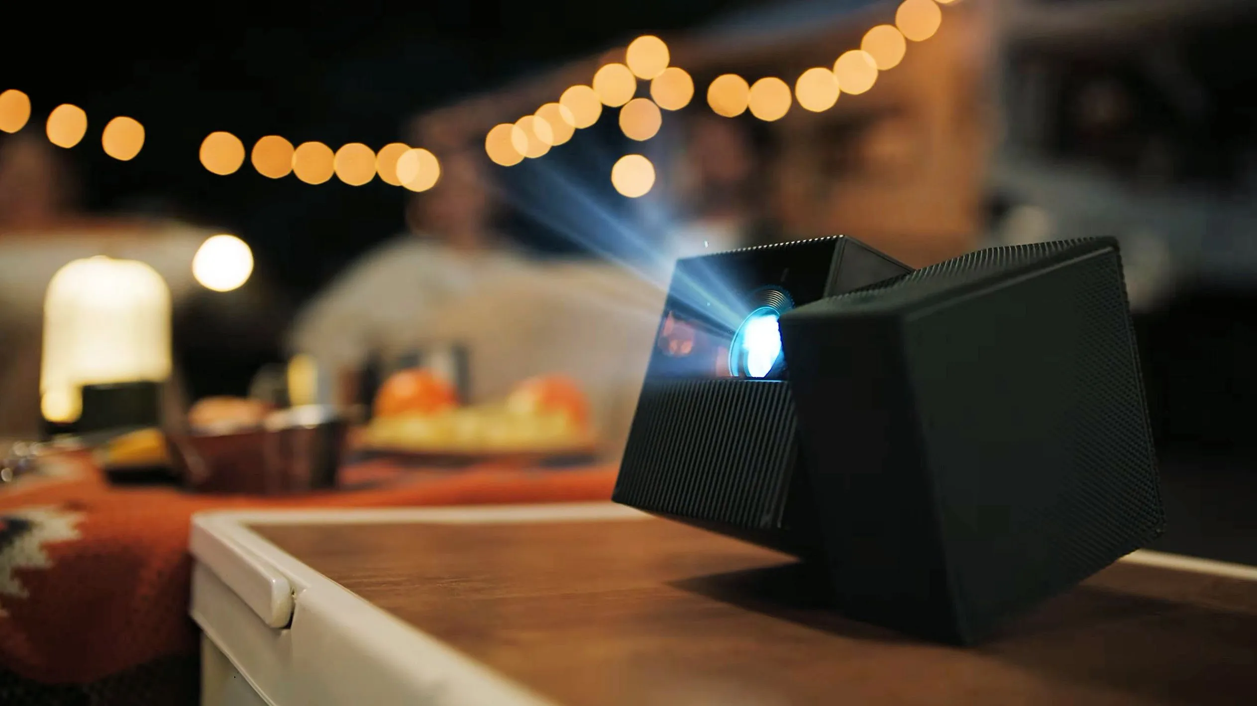 A 360-degree rotating hinge allows the projection block to tilt upward independently, casting a straight image even when placed on low outdoor tables