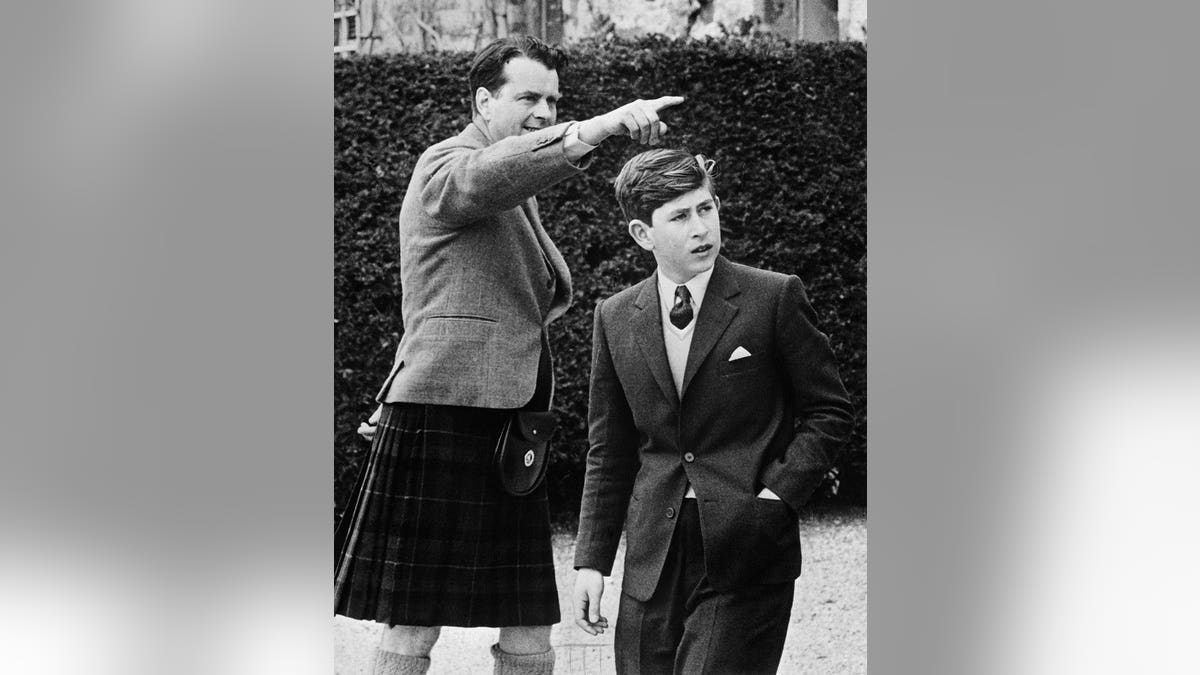 Prince Charles enters a school with Captain Ian Tennant in Elgin, United Kingdom.