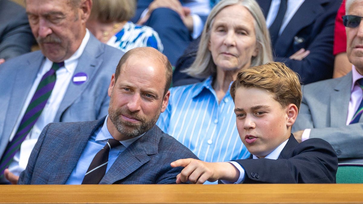 Prince William and Prince George sit in the Royal Box at Wimbledon.