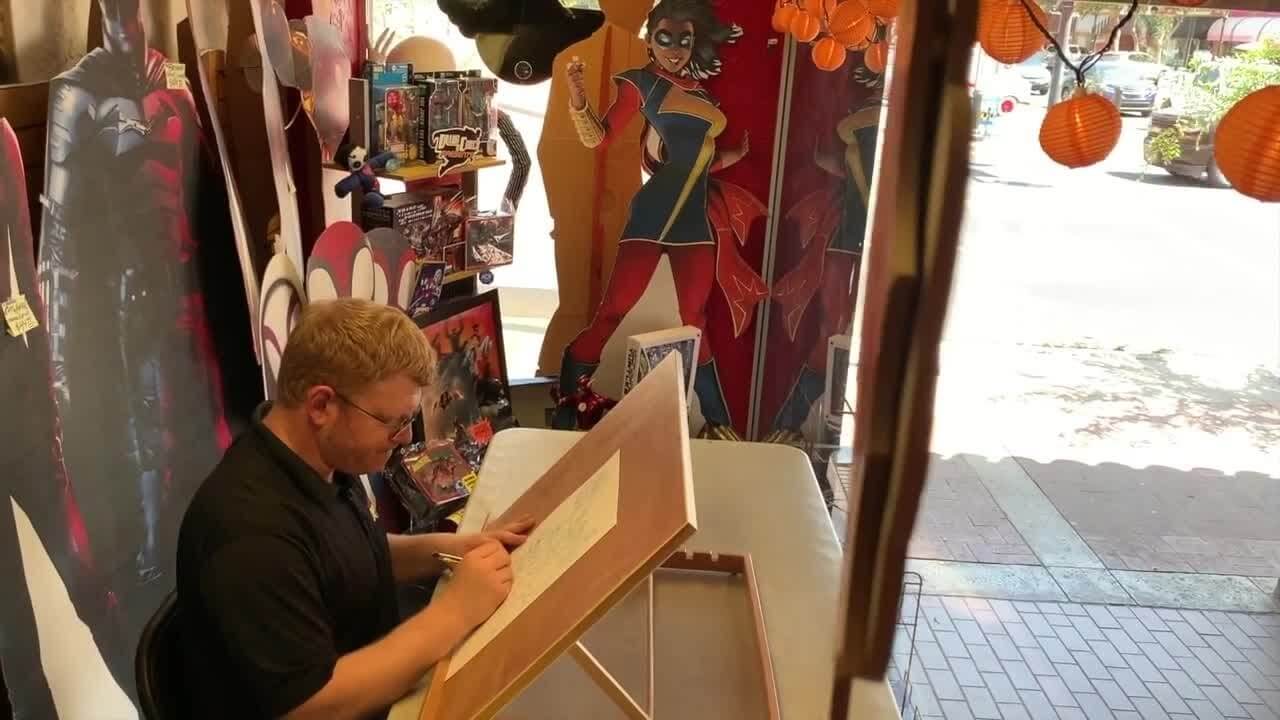 comic book artist sketching in store window