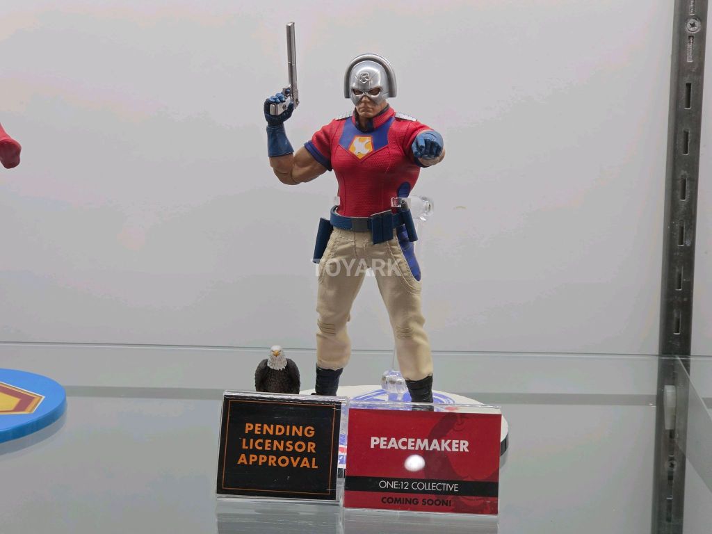 One:12 Collective SDCC DC Figures Peacemaker action figure in chrome helmet holding gun next to Eagly accessory