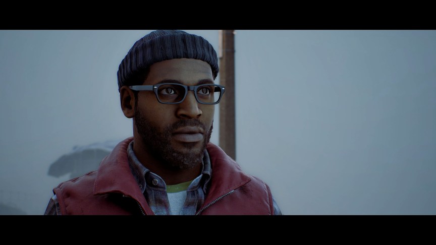 A man in a beanie and glasses looks on beyond the fog behind him.