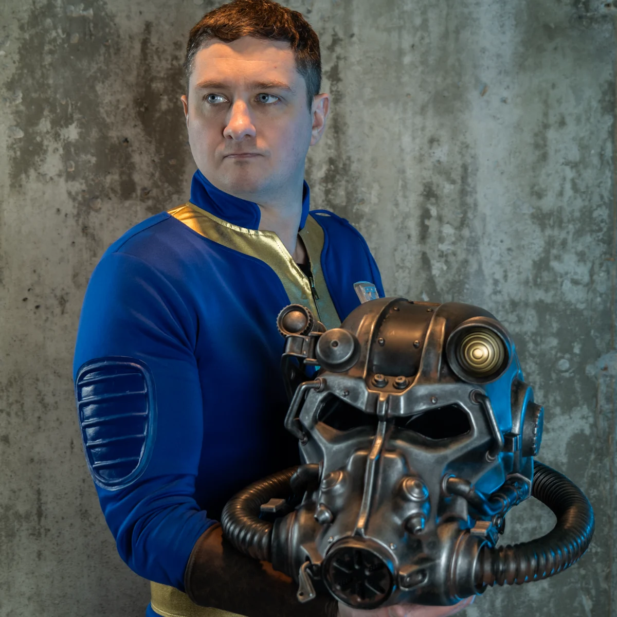 A vault dweller holds the Trick or Treat Studios Brotherhood helmet.