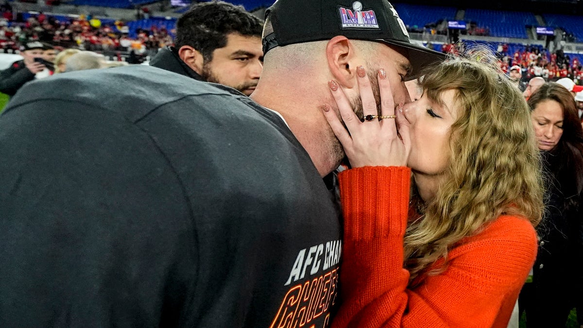 Travis Kelce and Taylor Swift kissing on the field