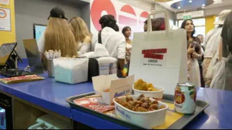 A tray of food is seen in a busy restaurant