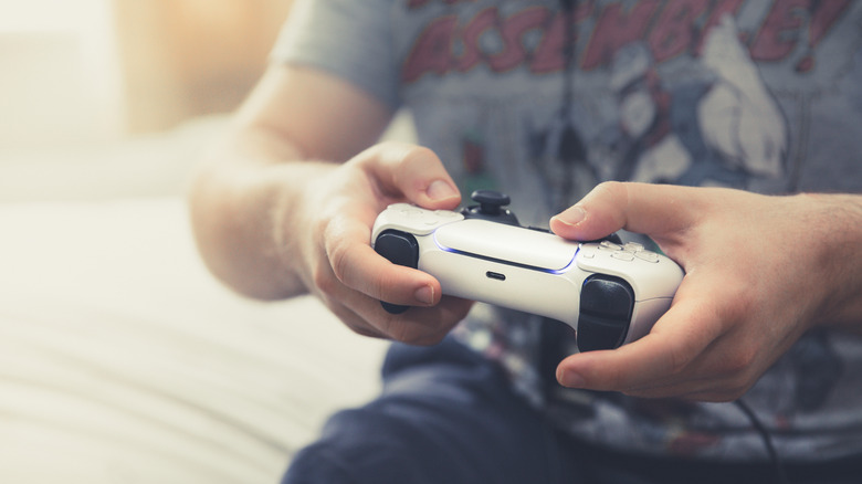 Person holding PlayStation 5 DualSense controller