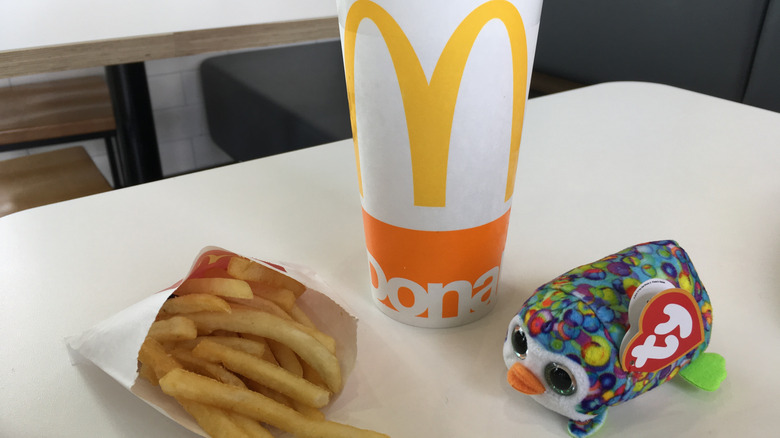 Fries, McDonald's drink, and Beanie Baby toy on table