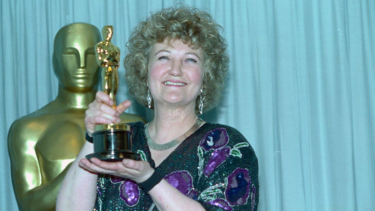Brenda Fricker holds up an Oscar at the Academy Awards.