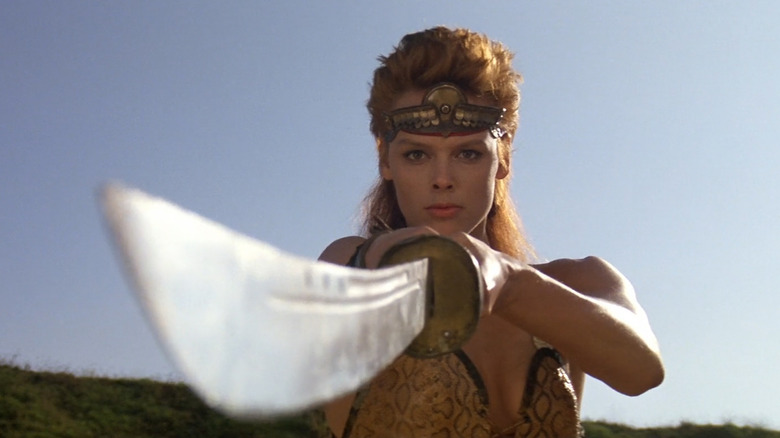 Red Sonja pointing a sword toward the camera in Red Sonja (1985)