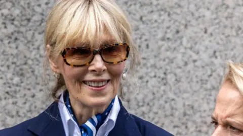 Getty Images E Jean Carroll seen leaving court in 2024. She wears large sunglasses