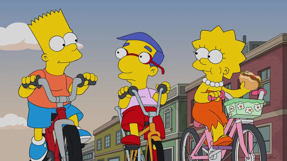 Animated characters Bart, Milhouse, and Lisa from "The Simpsons" are riding bikes on a street. Lisa holds a sandwich in her basket