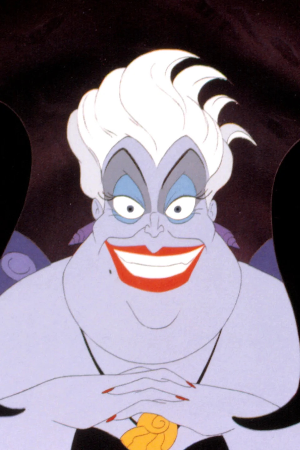 Animated sea witch character, Ursula, with white hair, red lips, and tentacles in a sinister pose from a classic film