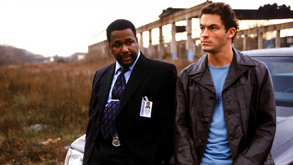 Bunk and McNulty sit on a car in The Wire.