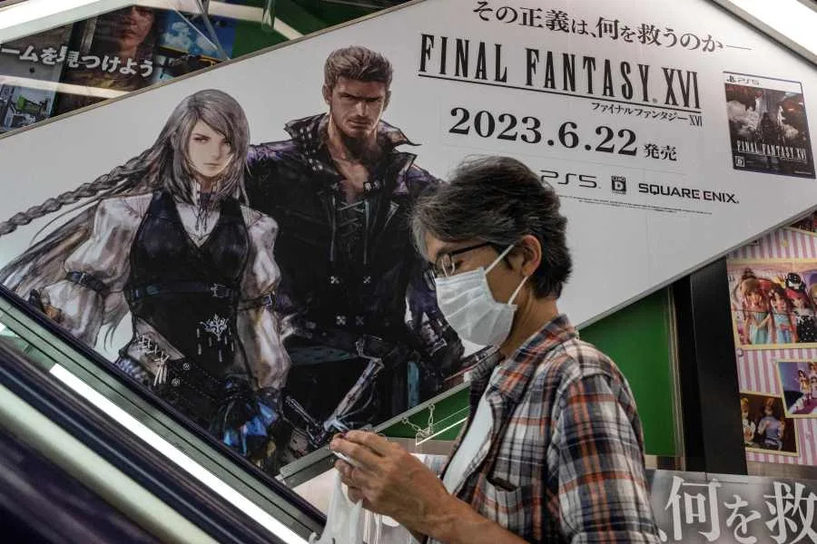 A man rides an escalator past an advertisement for Final Fantasy XVI - the latest version of the video game franchise developed and published by Square Enix - as it went on sale at an electronics store in central Tokyo on June 22, 2023. The eagerly awaited new game in the top-selling Final Fantasy franchise was released on June 22, with fans hailing its high-spec action graphics and grown-up storyline. (Photo by Richard A. Brooks / AFP) (Photo by RICHARD A. BROOKS/AFP via Getty Images)