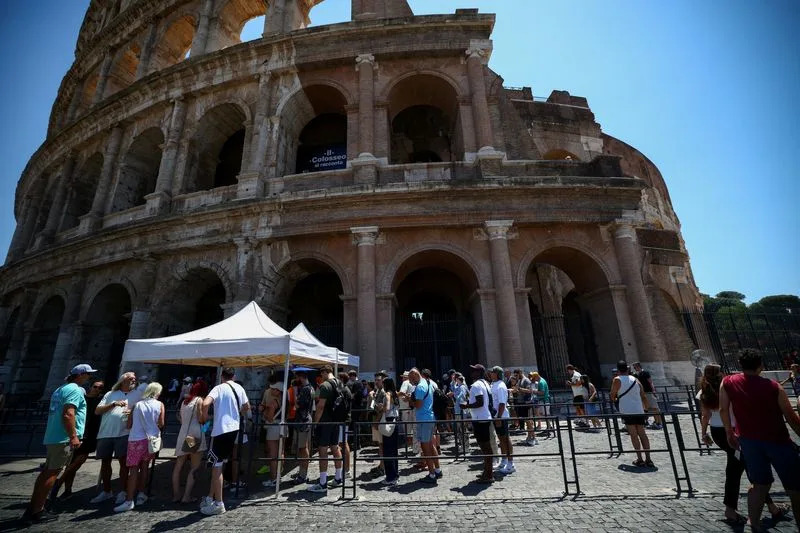 FILE PHOTO: Near the Temple of Claudius’s underground spaces, tourists brave the heat at Rome’s Colosseum