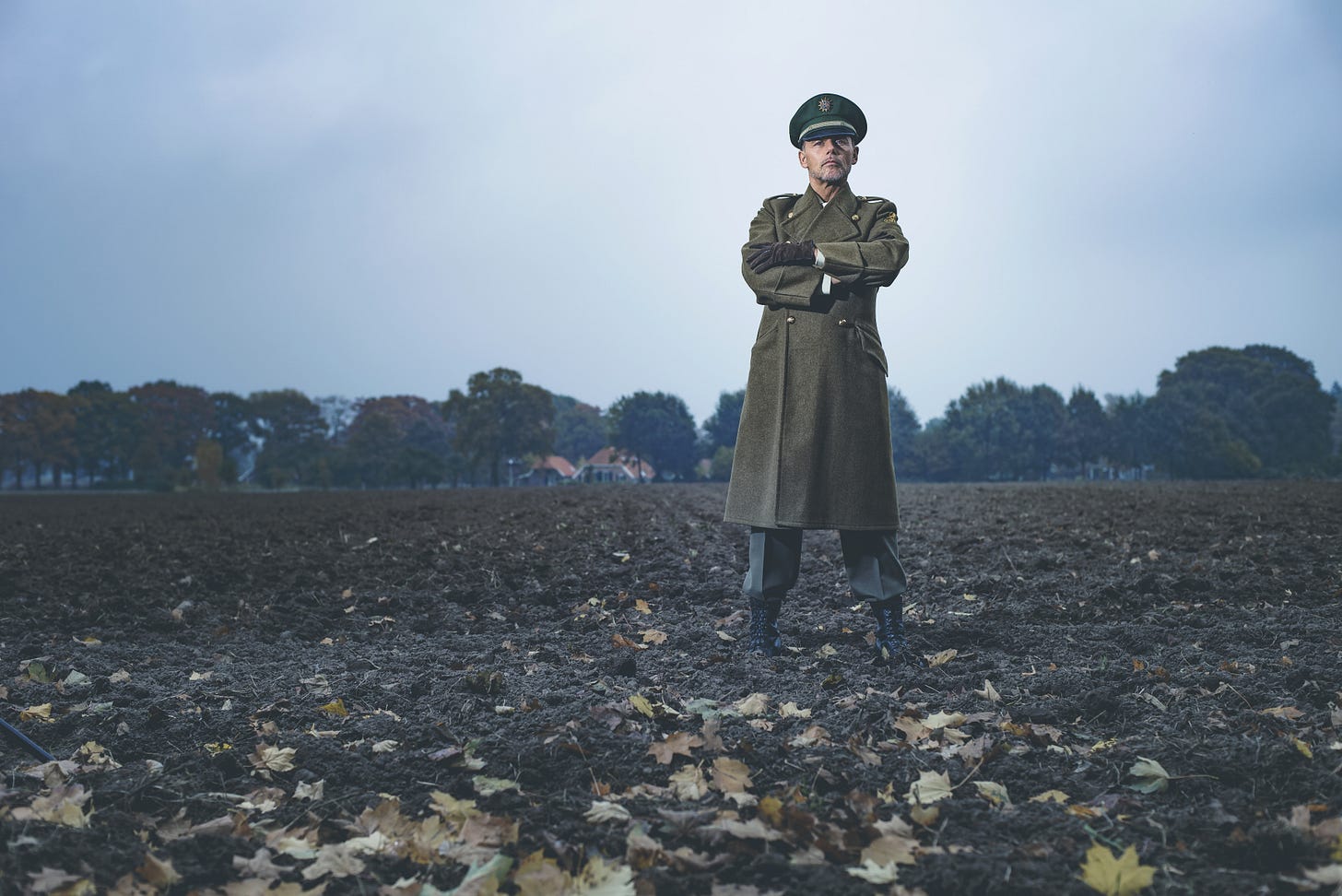 Nazi man standing in a field of fall foliage