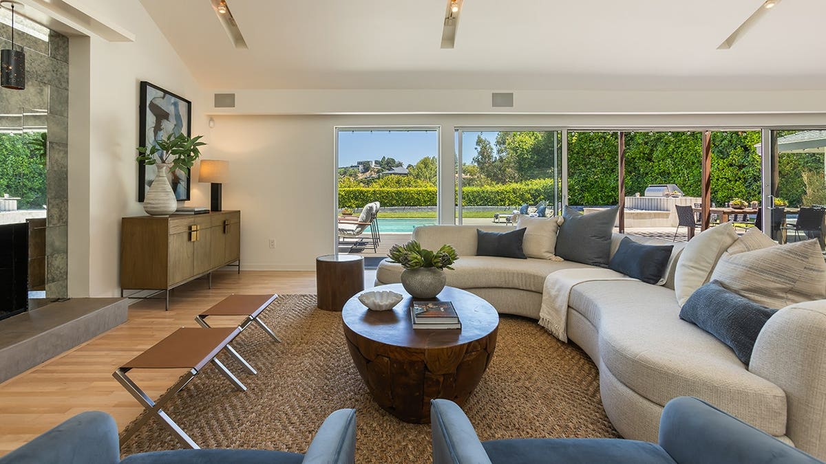 A living room with a sectional sofa and a fireplace.