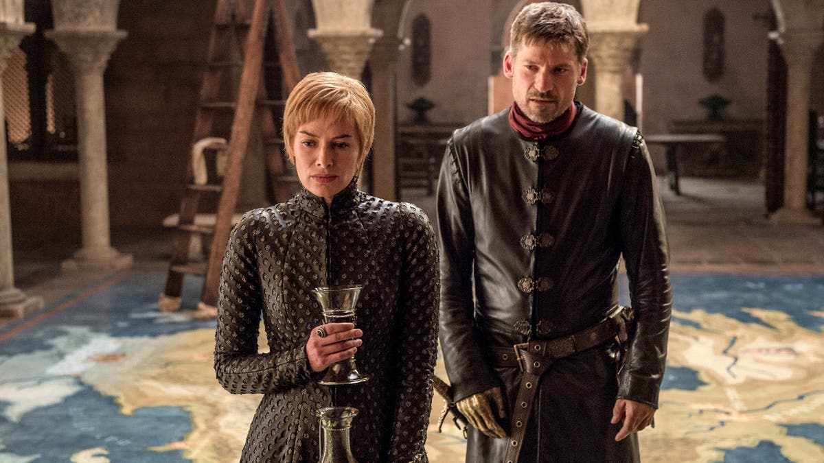 Lena Headey and Nikolaj Coster-Waldau in a scene from "Game of Thrones." Lena holds a wine glass as Nikolaj stands next to her.