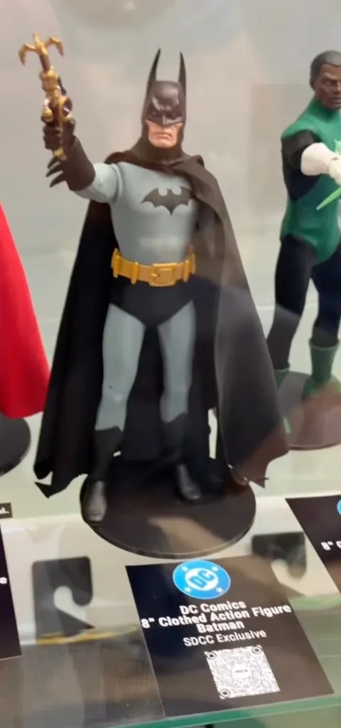 Display case featuring NECA DC 8-inch figures showing the SDCC exclusive comic Batman with a grapnel launcher.
