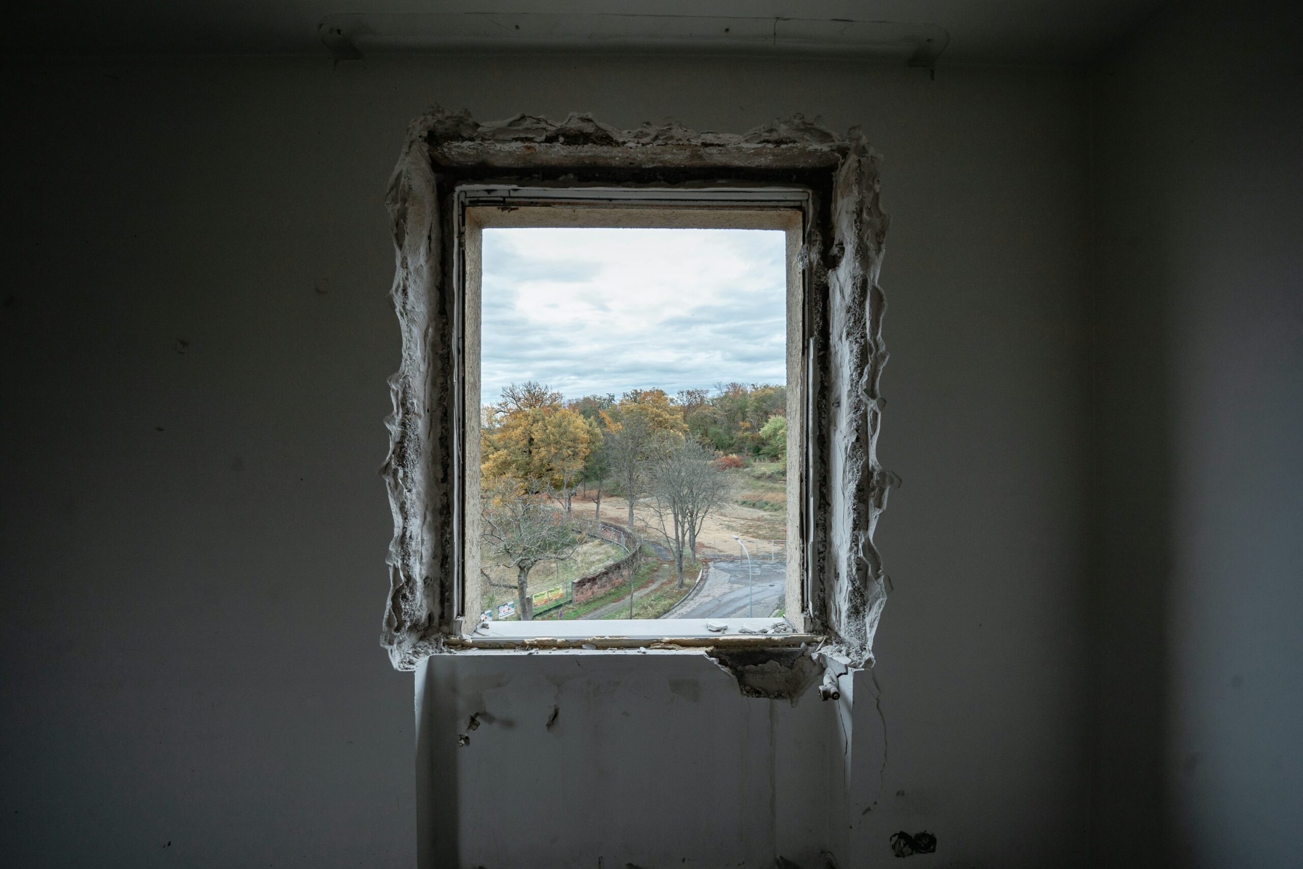 uma janela em um quarto com vista para as árvores