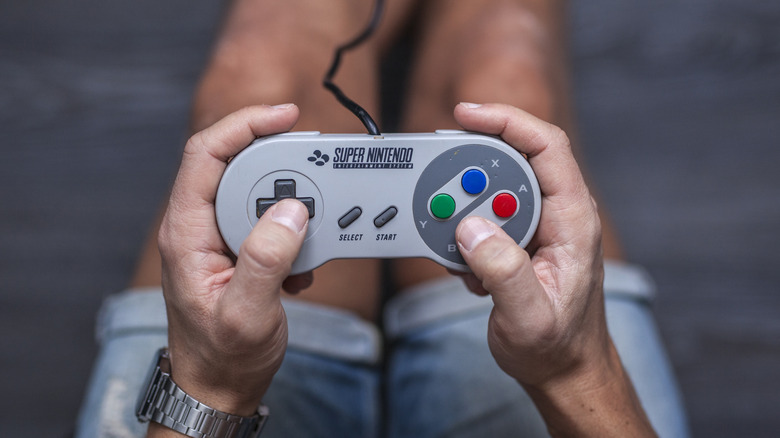 A person holding the SNES controller