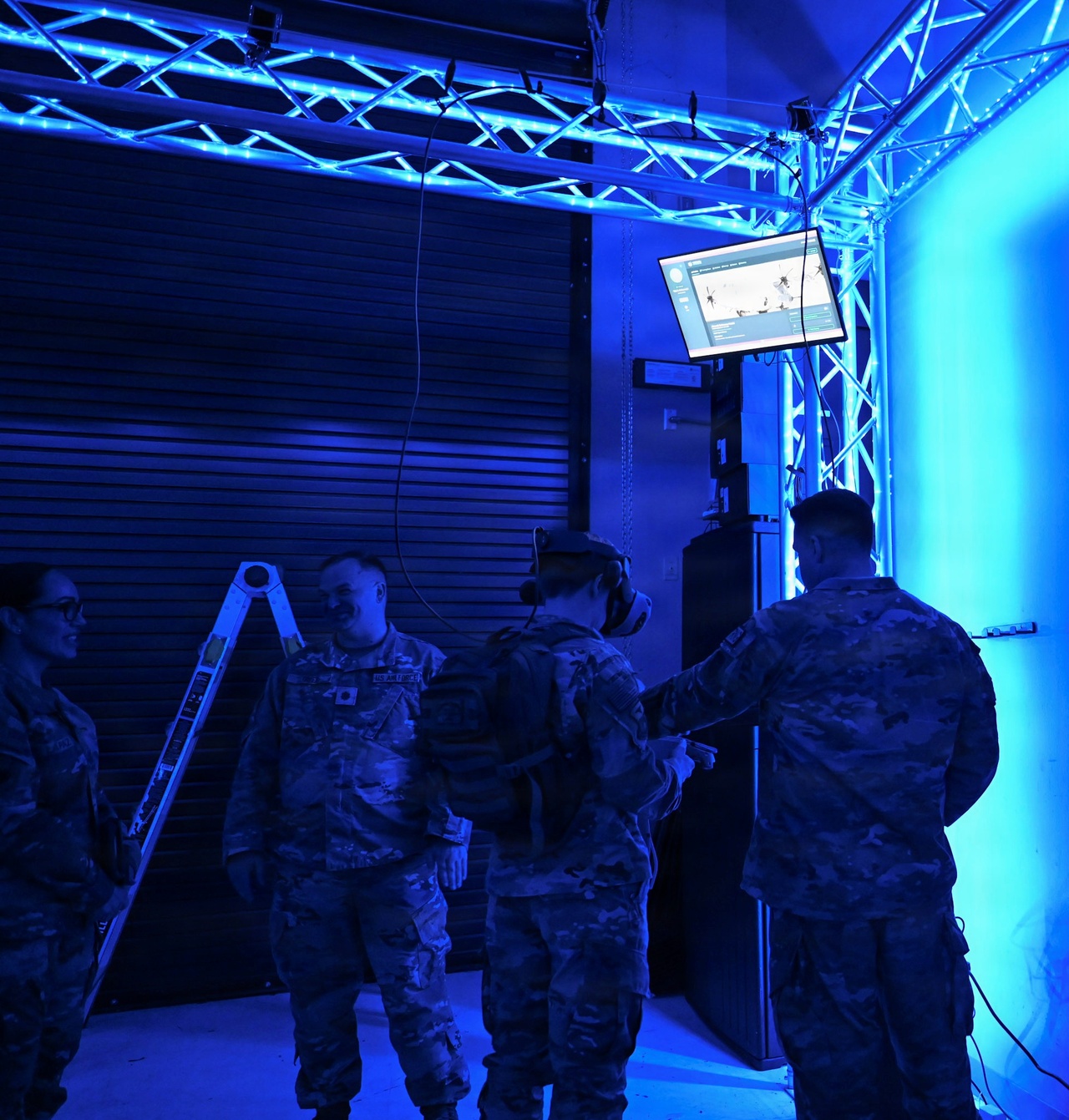 An Airman wearing a virtual reality headset in the 913th Airlift Group training center while another Airman operates a monitor showing the training software