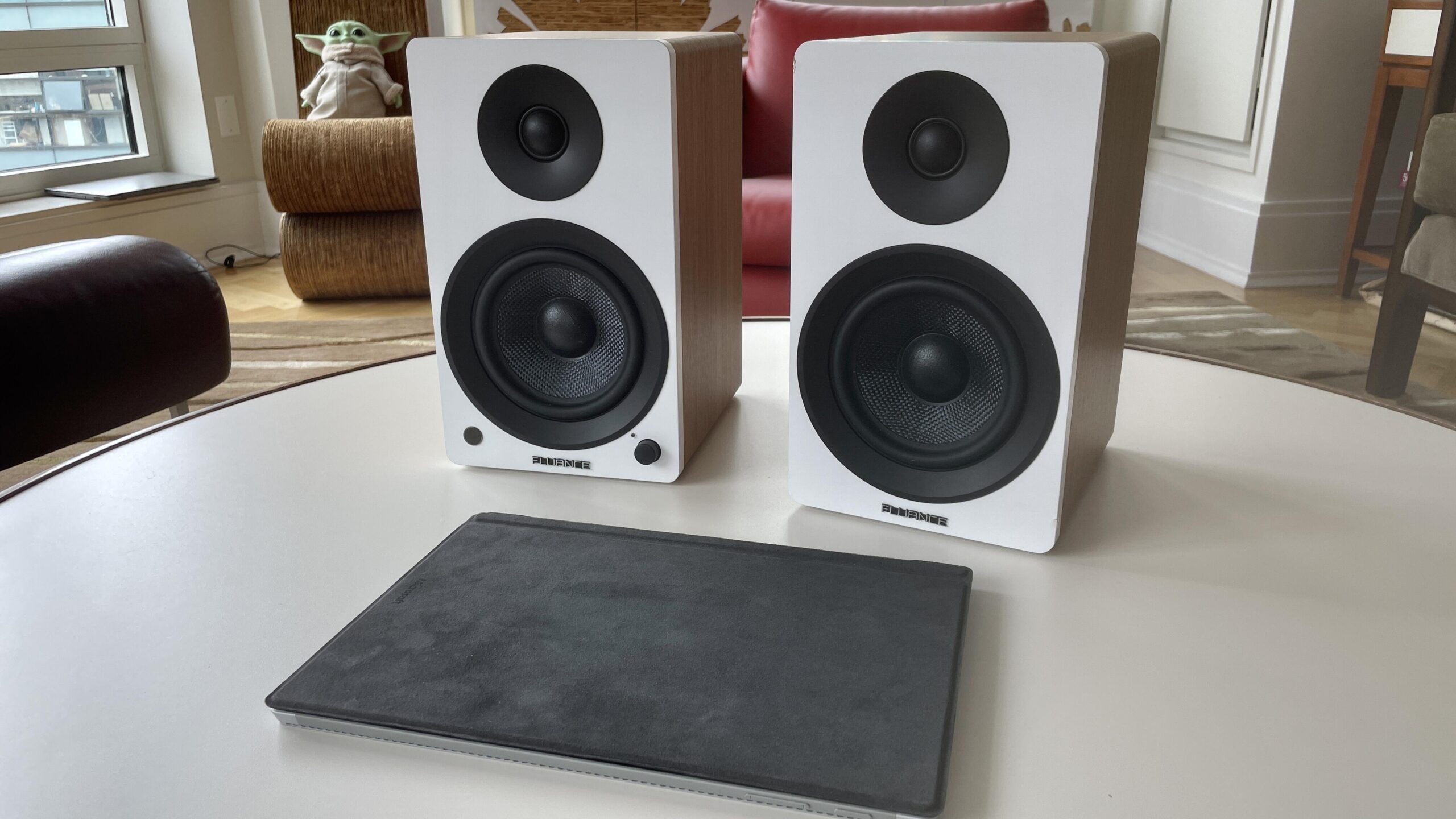 The white Fliuance AI41 Powered speakers on a living room coffee table.