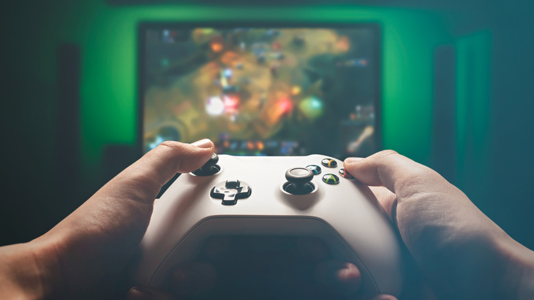 A person holding an Xbox controller and playing a game
