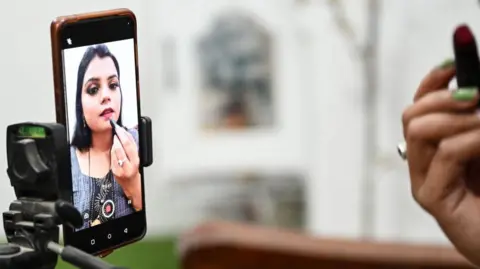 AFP via Getty Images An Indian social media make-up influencer pictured on her mobile screen, making tutorial videos in Bulandshahr, Uttar Pradesh.