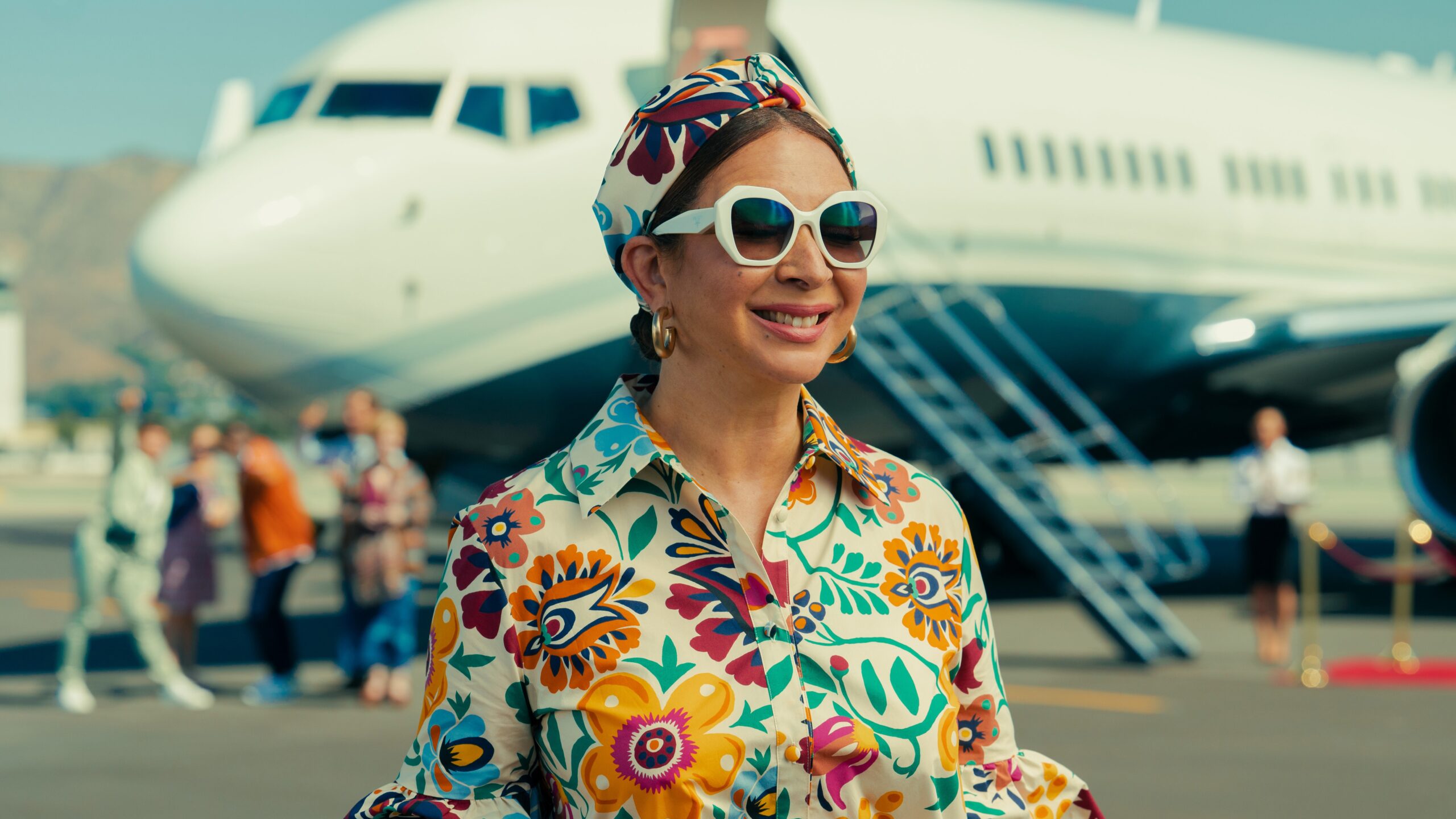 Maya Rudolph in sunglasses and a flowery blouse in the show Loot