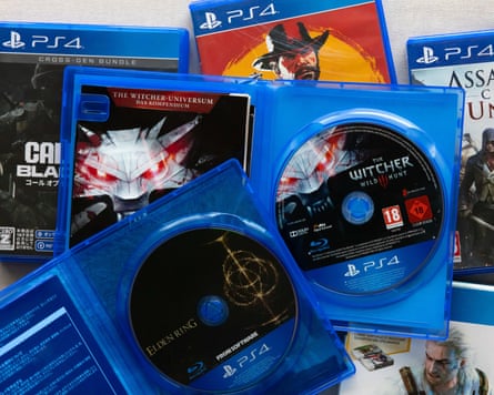 Open cases with physical discs of PlayStation 4 games “The Witcher 3”, “Call of Duty Black Ops 6”, “Red Dead Redemption 2” and “Assassin’s Creed Unity”.