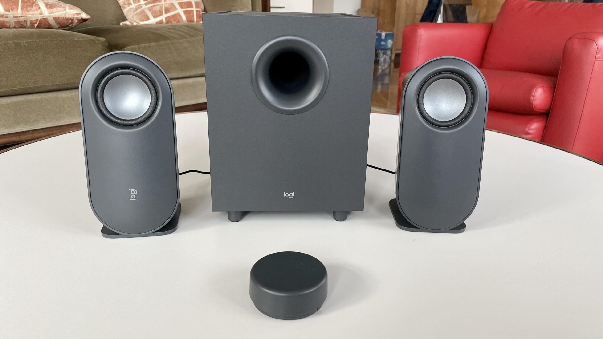 The grey Logitech z407 speakers set up on a white coffee table.