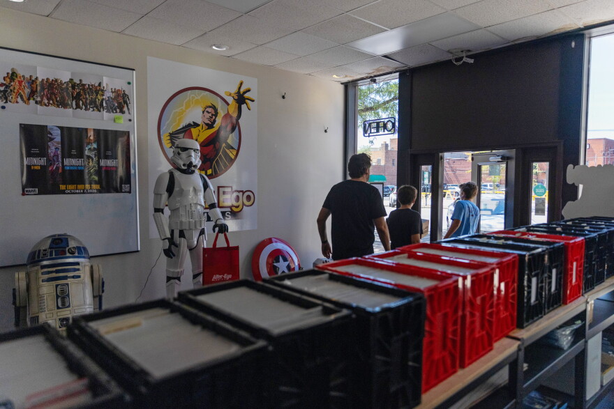 Customers walk by lifesize models of R2-D2 and a Stormtrooper from Star Wars as they exit the store.