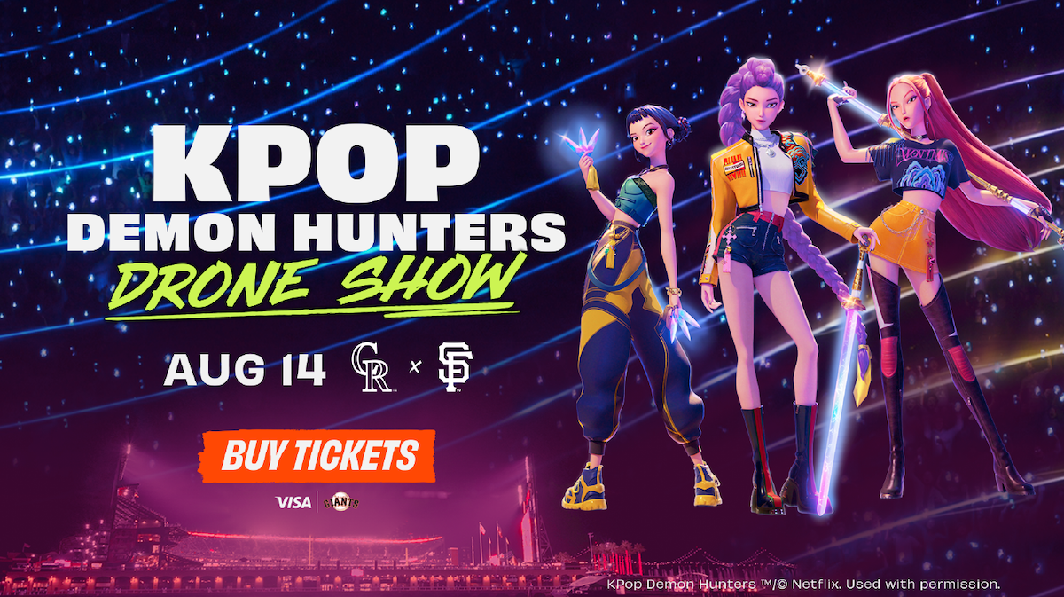 Three animated K-pop styled characters pose with glowing swords at night in a neon-lit city stadium. Text promotes "KPOP Demon Hunters Drone Show" on August 14, with teams, ticket info, and sponsor logos.