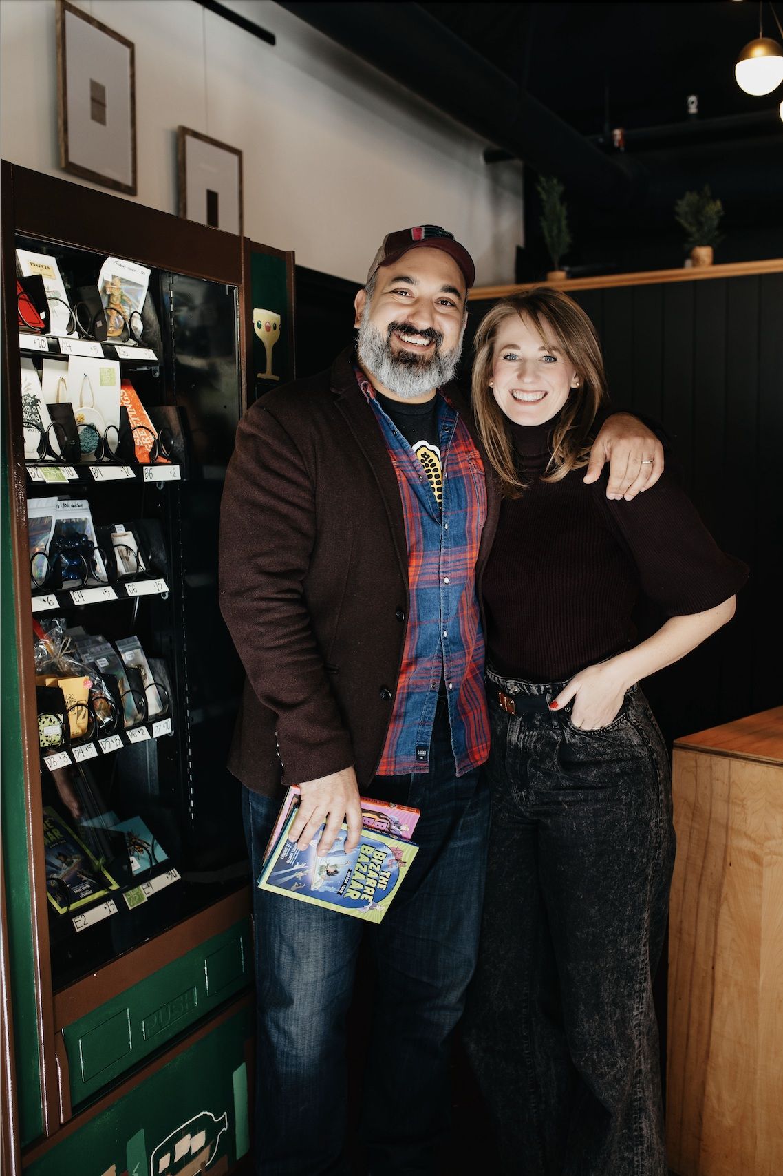 Authors Daniel Nayeri and Alexandra Davis standing by their vending machine. Photo from publicist