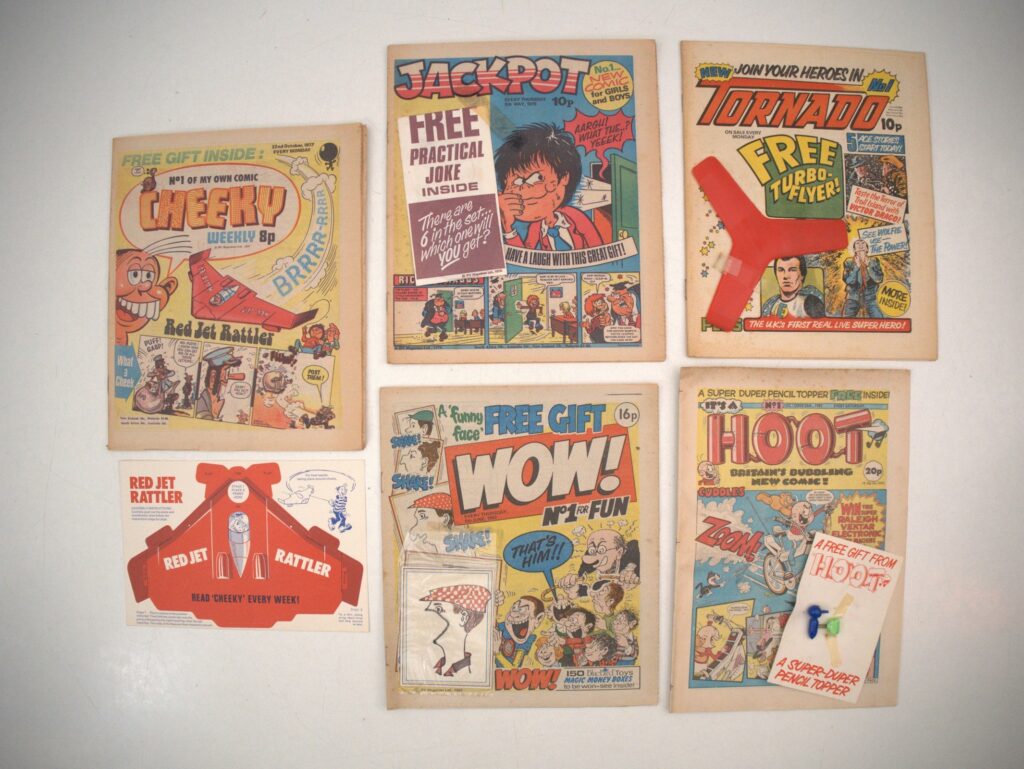 MIXED BRITISH FIRST ISSUE FREE GIFT LOT (5 in Lot) - Includes CHEEKY #1 (1977 - IPC) with FREE GIFT RED JET RATTLER (UNPUNCHED) + JACKPOT #1 (1979 - IPC) with FREE GIFT PRACTICAL JOKE + TORNADO #1 (1979 - IPC) with FREE GIFT TURBO-FLYER + WOW! #1 (1982 - IPC) with FREE GIFT FUNNY FACE SHAKER + HOOT #1 (1985 - D.C. THOMSON) with FREE GIFT PENCIL TOPPER